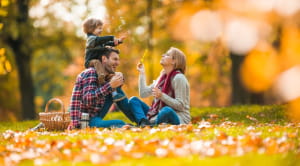 Family sitting in autumn forest blowing bubbles Getty Images
